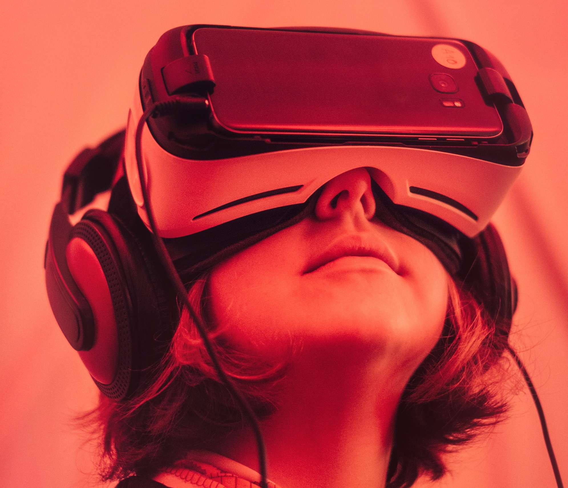 Bild einer Frau, die eine Virtual Reality Brille trägt mit rotem Licht.